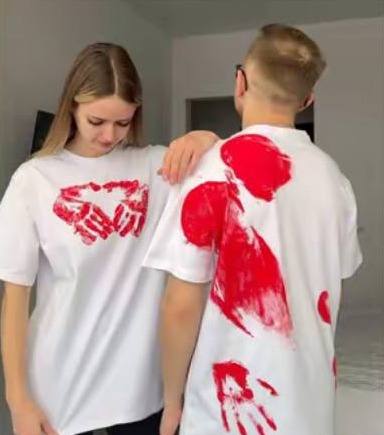 Пара в білих футболках з червоними відбитками долонь